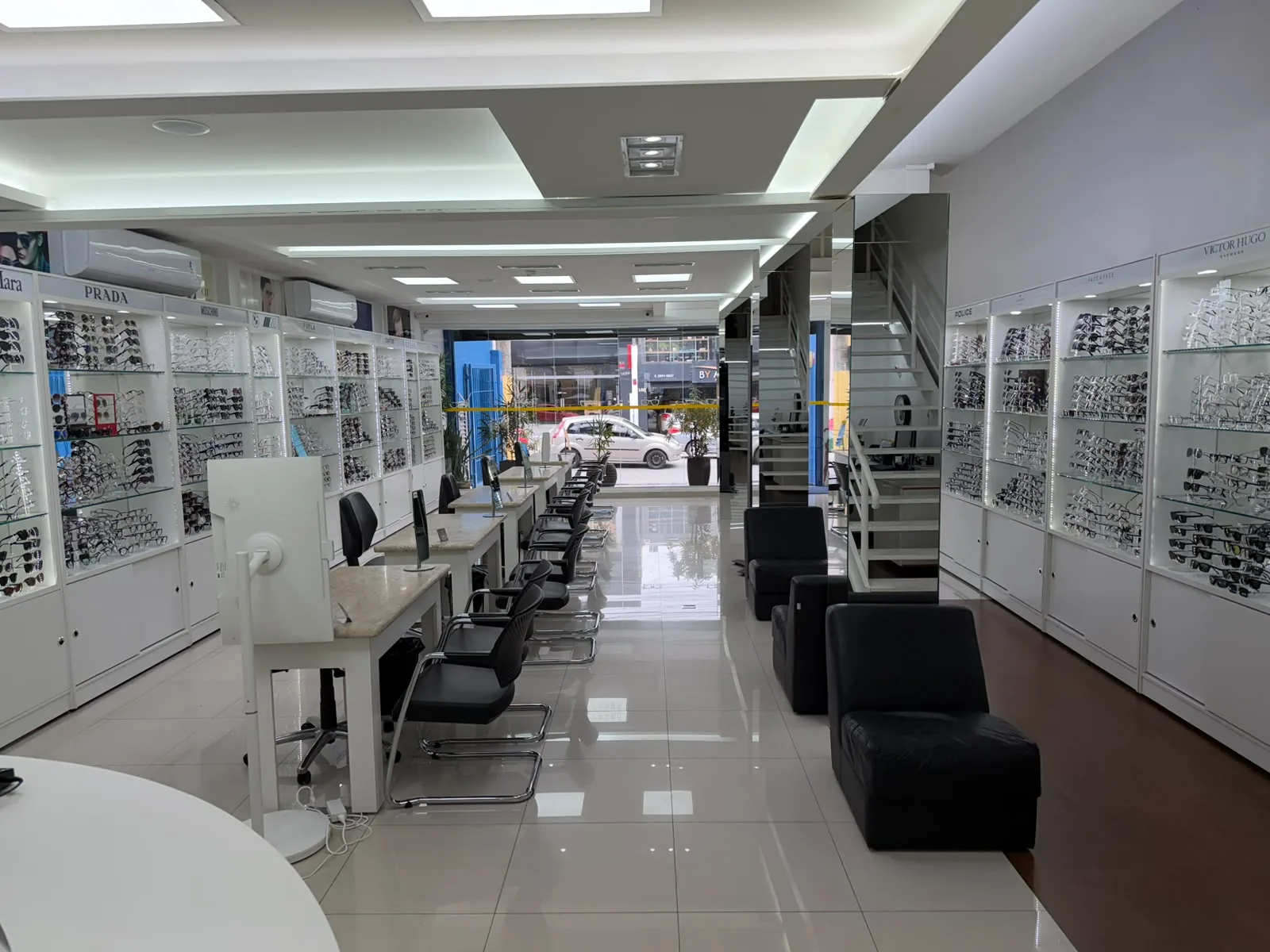 Interior amplo da Consultoria Óptica Village com exposição de armações